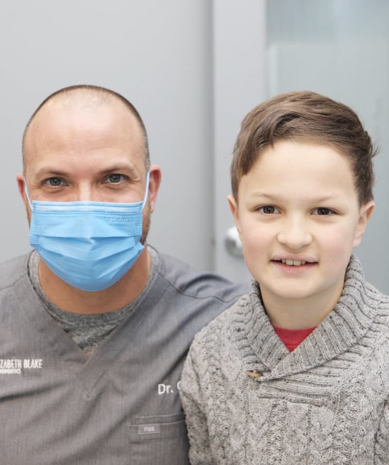 doctor and young boy smiling after getting braces